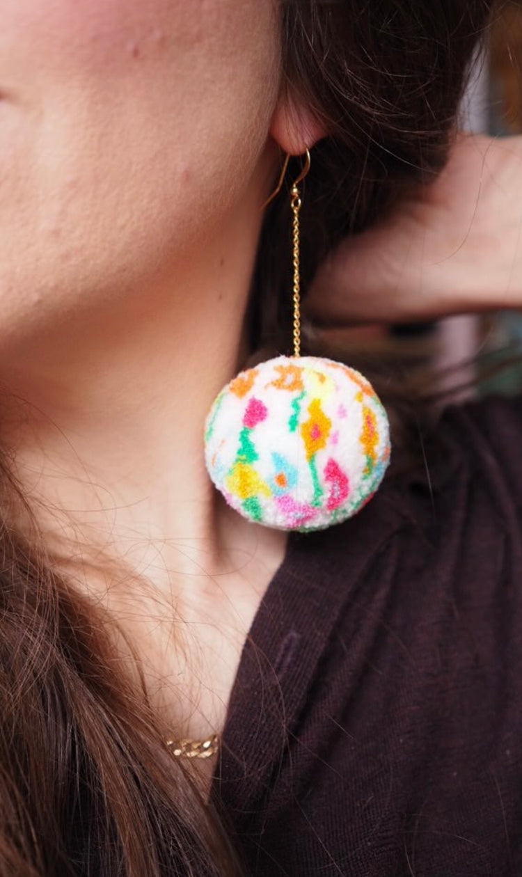 Pendientes de pompones con diseño floral abstracto