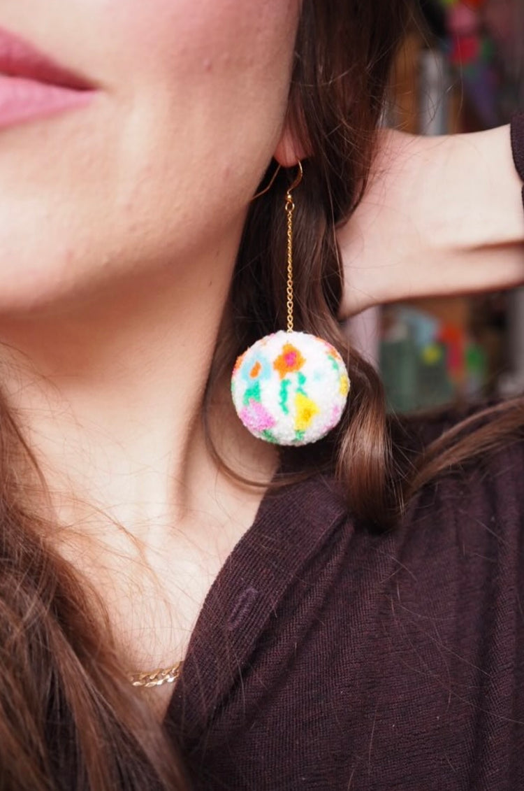 Pendientes de pompones con diseño floral abstracto