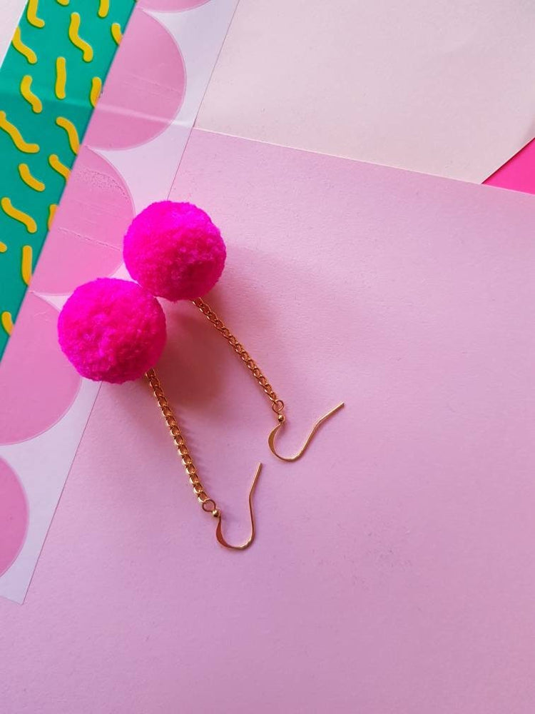 Pendientes de pompones de color rosa brillante