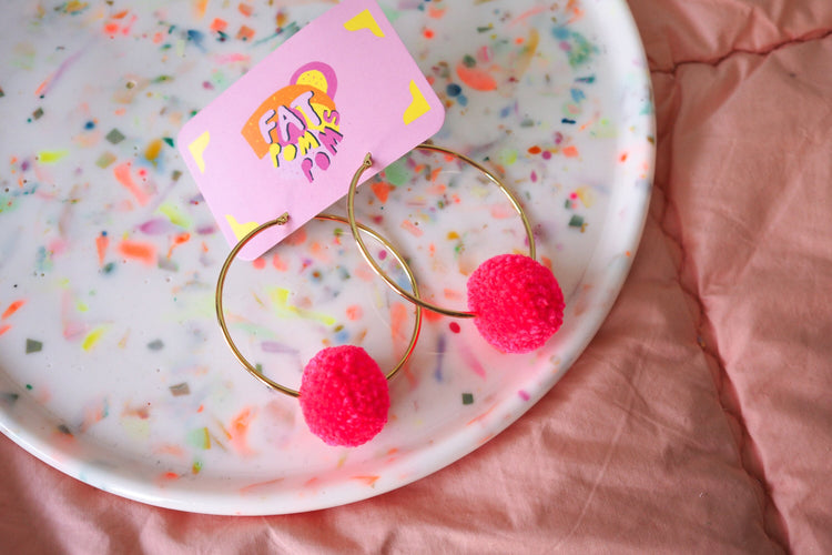 Pendientes de pompones de color rosa brillante