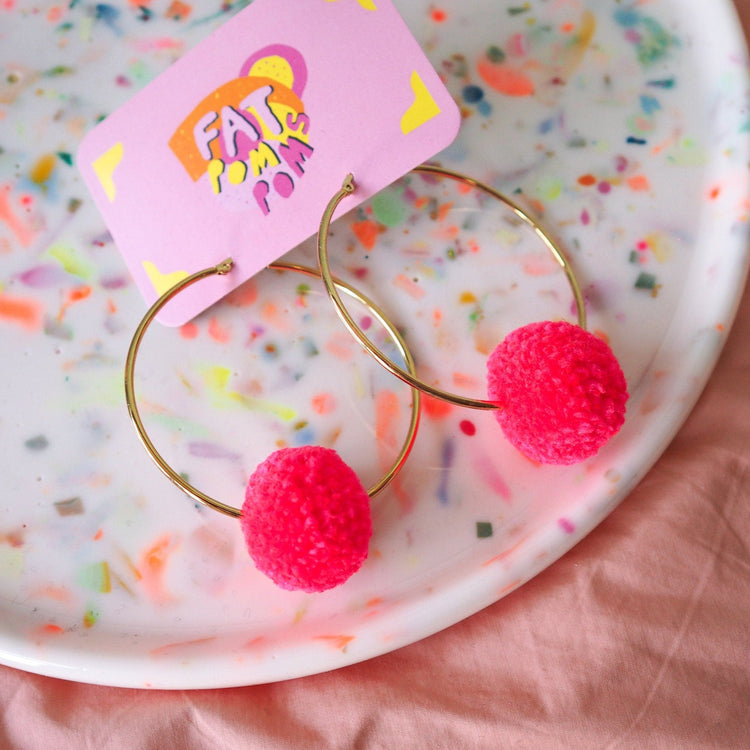 Pendientes de pompones de color rosa brillante