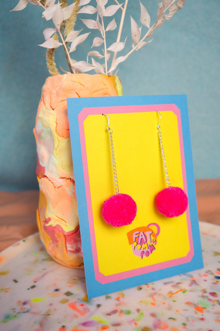 Pendientes de pompones de color rosa brillante