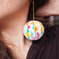 Pendientes de pompones con diseño floral abstracto